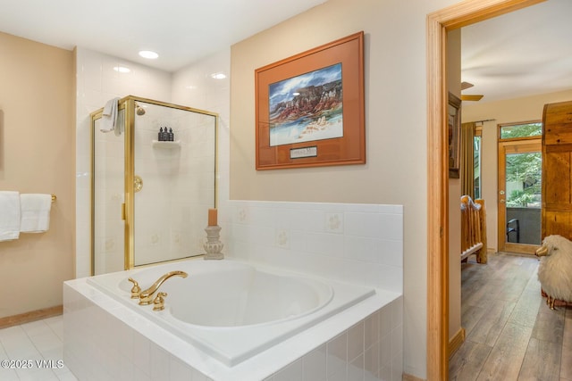 74 Cresta Rd Unit 106, Edwards, CO 81632 - full bathroom featuring a garden tub, a shower stall, baseboards, and wood finished floors