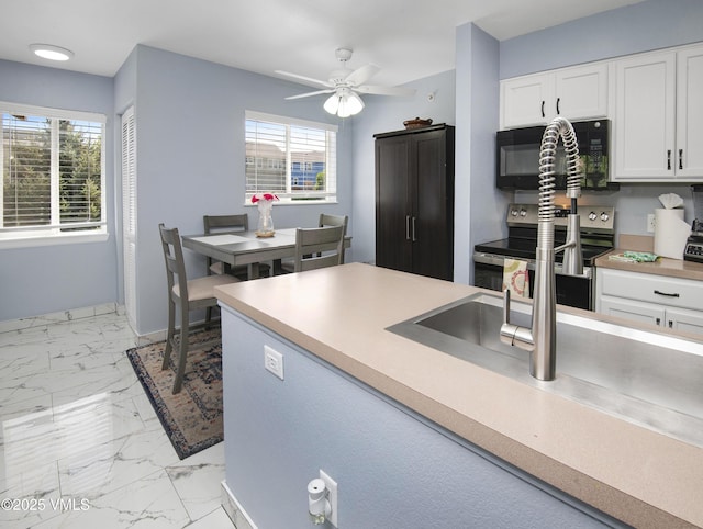 127 Jules Dr Unit D-204, Gypsum, CO 81637 - kitchen featuring black microwave, stainless steel range with electric stovetop, white cabinets, and plenty of natural light