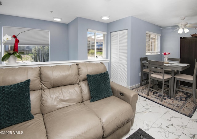 127 Jules Dr Unit D-204, Gypsum, CO 81637 - living room featuring healthy amount of natural light, marble look tiles, baseboards, and ceiling fan