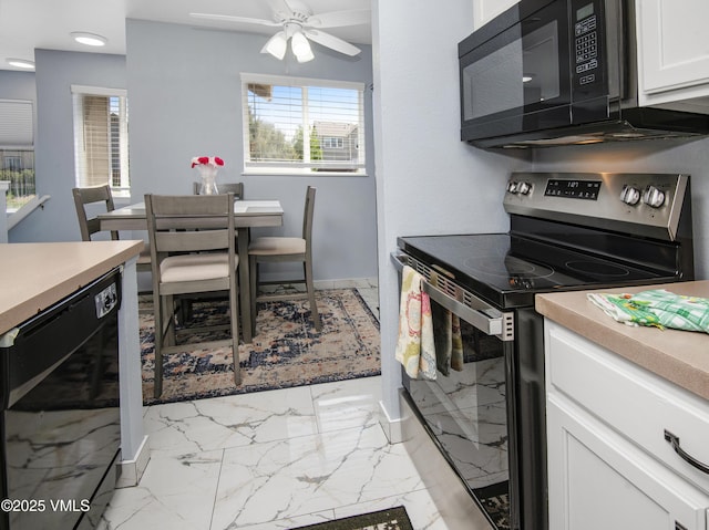 127 Jules Dr Unit D-204, Gypsum, CO 81637 - kitchen with stainless steel range with electric stovetop, black microwave, light marble finish flooring, white cabinetry, and wine cooler