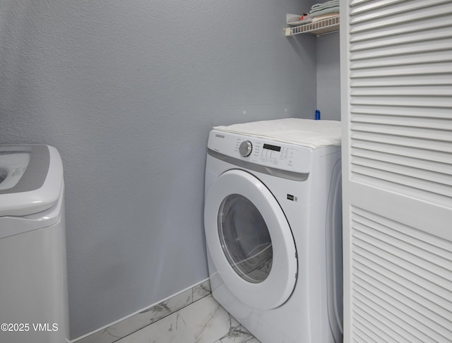 127 Jules Dr Unit D-204, Gypsum, CO 81637 - laundry room featuring separate washer and dryer, light marble finish floors, and baseboards