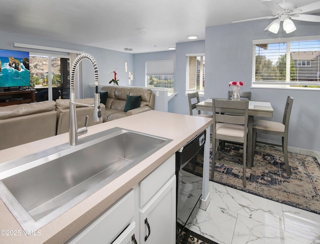 127 Jules Dr Unit D-204, Gypsum, CO 81637 - kitchen featuring a sink, black dishwasher, open floor plan, light marble finish flooring, and white cabinets