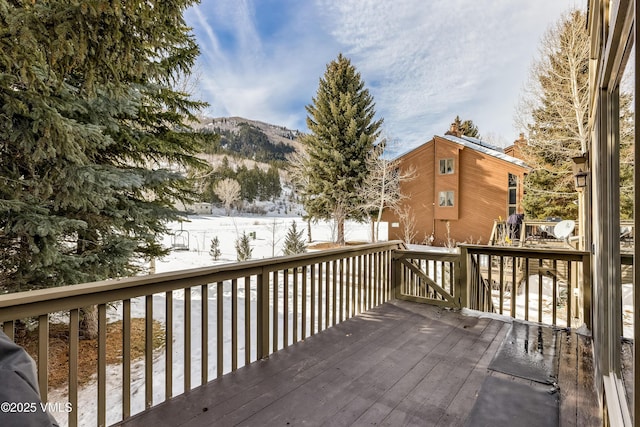 snow covered deck with a mountain view