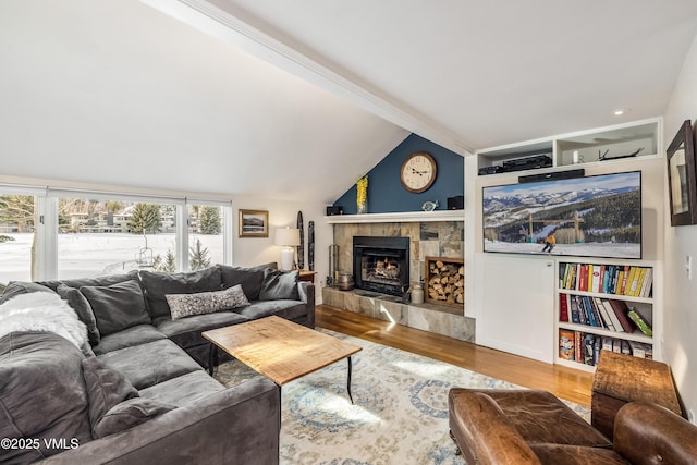 living room featuring a tile fireplace, lofted ceiling, and wood finished floors