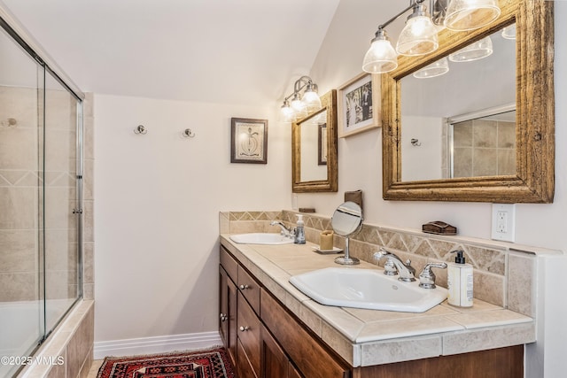 bathroom featuring double vanity, baseboards, and a sink