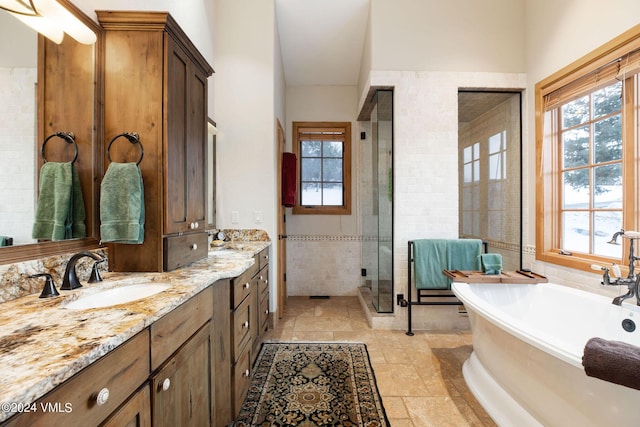 bathroom featuring vanity, separate shower and tub, and tile walls