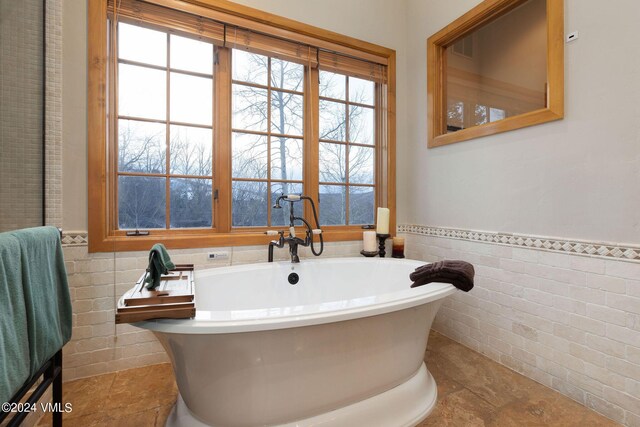 bathroom featuring a bathing tub and tile walls