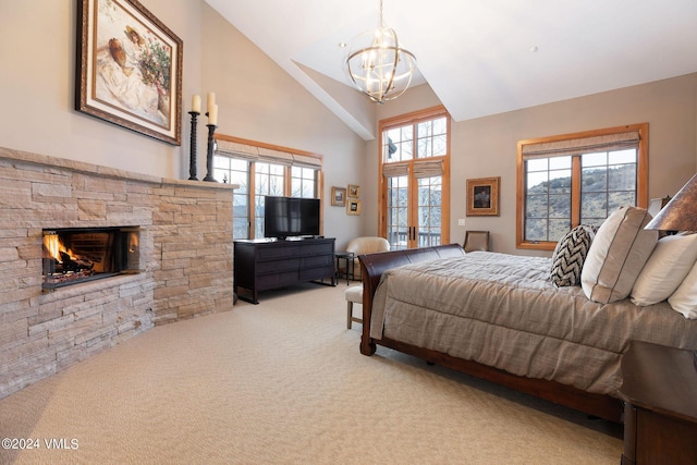 bedroom featuring french doors, a chandelier, high vaulted ceiling, light colored carpet, and a fireplace