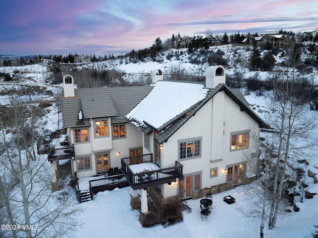 snow covered house with a wooden deck