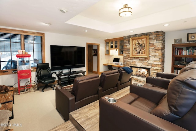 carpeted living room featuring a raised ceiling and a fireplace