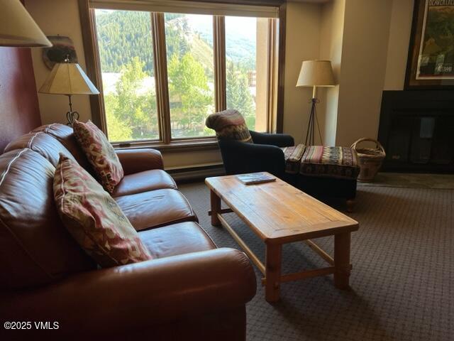 living room with carpet floors and a glass covered fireplace