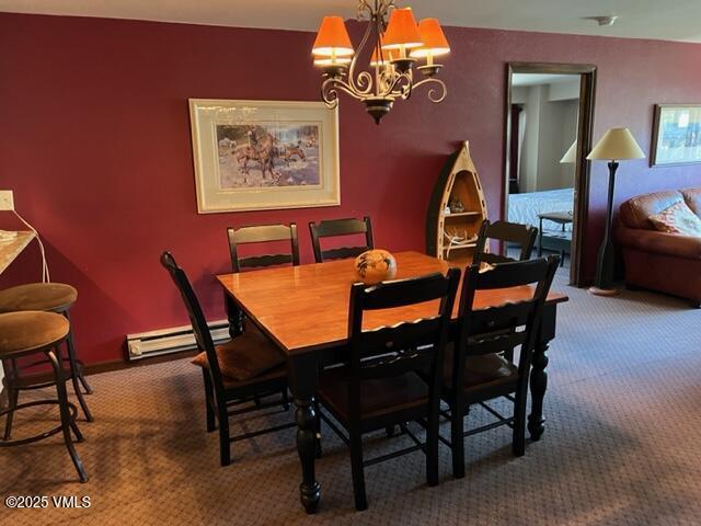 dining space with a notable chandelier, a baseboard radiator, and carpet flooring