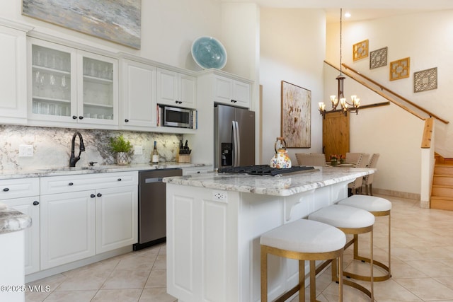 21 Hackamore Rd W, Edwards, CO 81632 - kitchen with stainless steel appliances, a towering ceiling, a sink, light tile patterned flooring, and a chandelier