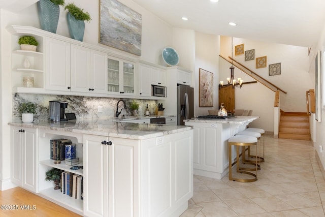 21 Hackamore Rd W, Edwards, CO 81632 - kitchen with open shelves, stainless steel appliances, white cabinets, a sink, and tasteful backsplash