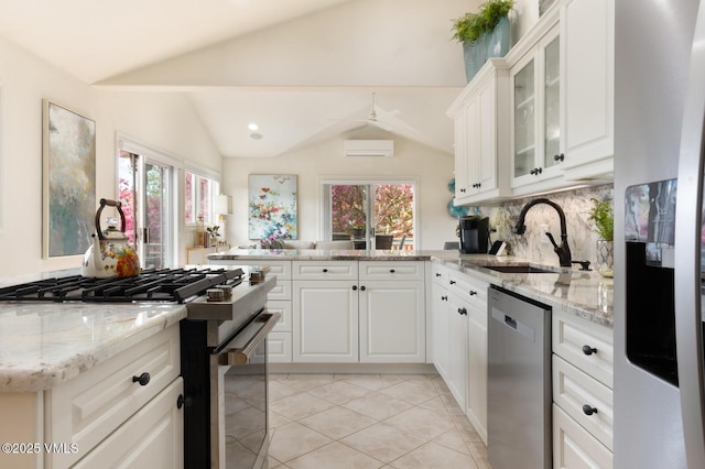 21 Hackamore Rd W, Edwards, CO 81632 - kitchen featuring appliances with stainless steel finishes, vaulted ceiling, a sink, decorative backsplash, and glass insert cabinets