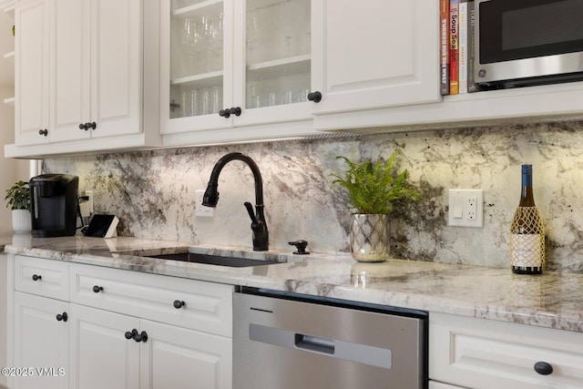 21 Hackamore Rd W, Edwards, CO 81632 - kitchen with stainless steel appliances, a sink, white cabinetry, and decorative backsplash