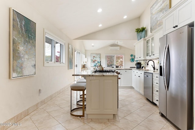 21 Hackamore Rd W, Edwards, CO 81632 - kitchen with stainless steel appliances, a sink, vaulted ceiling, a breakfast bar area, and white cabinetry