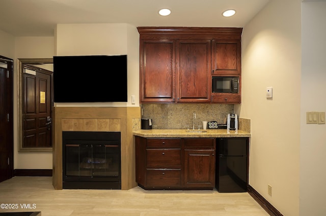 26 Avondale Ln Unit 313-H, Beaver Creek, CO 81620 - kitchen featuring black microwave, refrigerator, tasteful backsplash, a sink, and light wood-style flooring