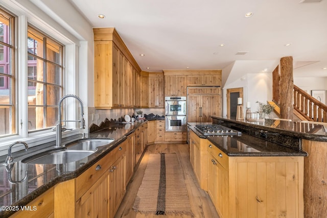 37 Hawley Ct, Edwards, CO 81632 - kitchen with stainless steel appliances, light wood-type flooring, a large island, dark stone counters, and decorative backsplash