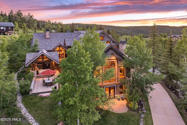 37 Hawley Ct, Edwards, CO 81632 - back of house at dusk featuring a deck with mountain view and a chimney