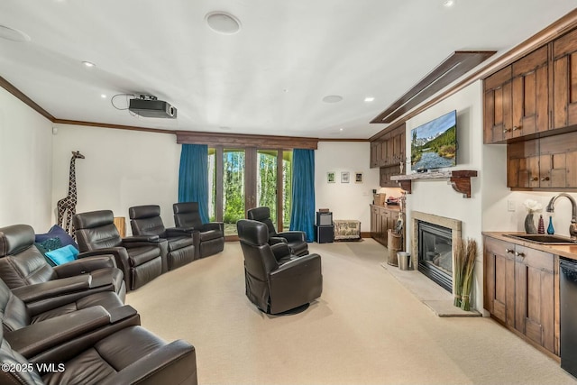 cinema featuring recessed lighting, light carpet, a sink, a glass covered fireplace, and crown molding