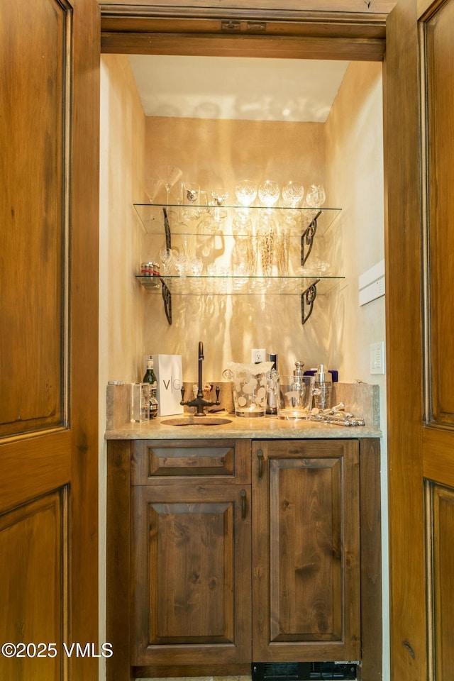 bar with indoor wet bar and a sink