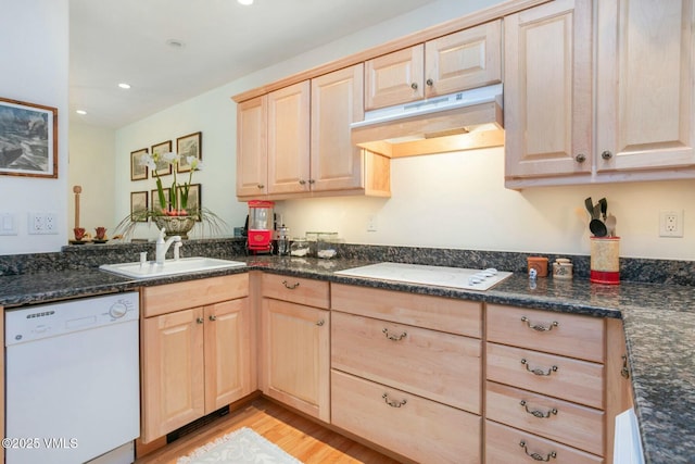 kitchen featuring light wood finished floors, light brown cabinets, a sink, white appliances, and under cabinet range hood