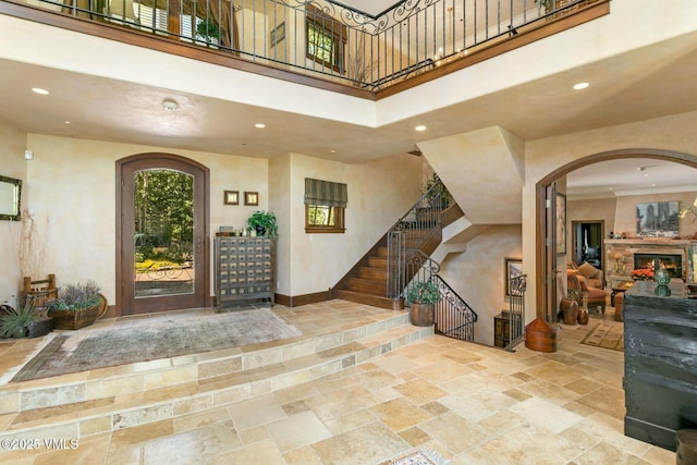 foyer entrance with recessed lighting, stone tile flooring, baseboards, and a high ceiling