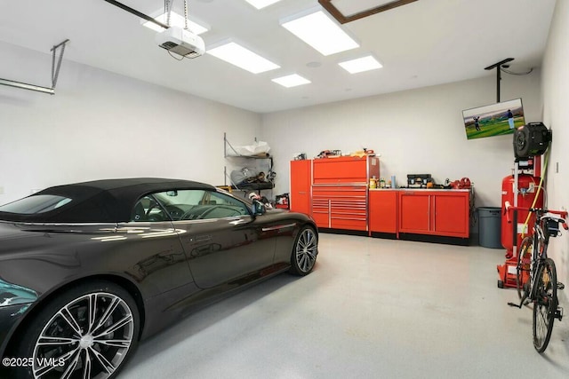 garage with a garage door opener and a workshop area