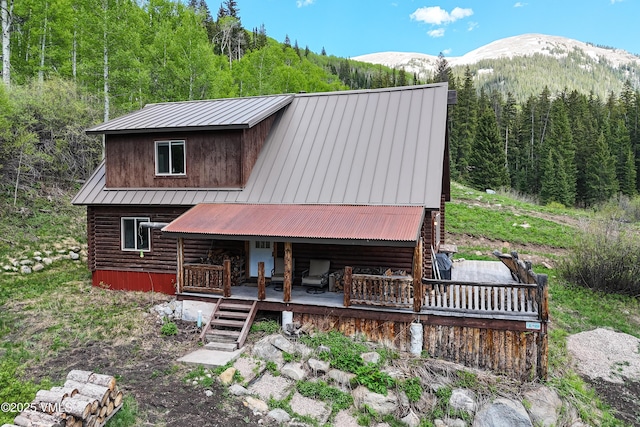 320 Mill, Eagle, CO 81631 - view of front facade with a view of trees, log siding, a metal roof, and a deck with mountain view