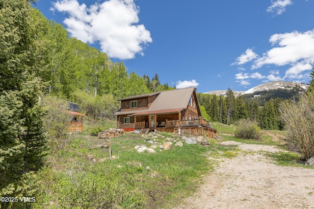 320 Mill, Eagle, CO 81631 - view of front facade featuring a view of trees, log siding, a porch, and a metal roof