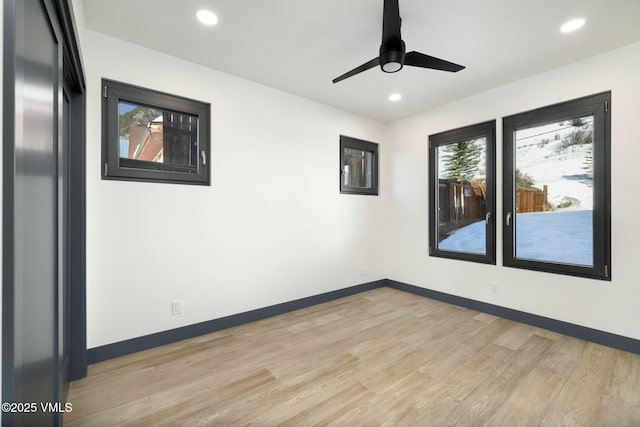 empty room featuring light wood finished floors, baseboards, and recessed lighting