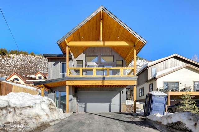 view of front facade with a garage, driveway, and a balcony