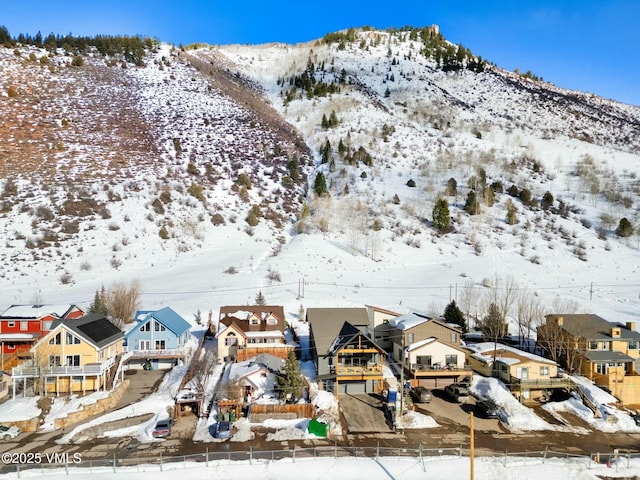 snowy aerial view with a residential view and a mountain view