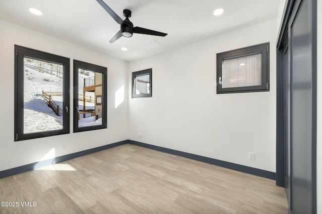 unfurnished room featuring light wood finished floors, baseboards, and recessed lighting