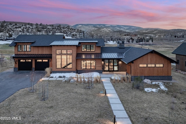 view of front of home with a mountain view, driveway, metal roof, and a standing seam roof