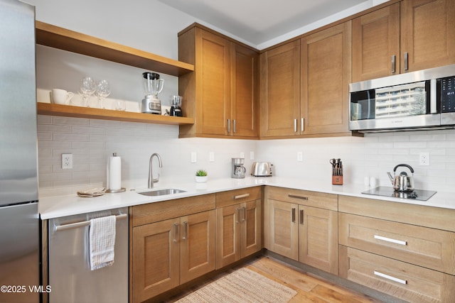 kitchen with stainless steel appliances, a sink, light countertops, backsplash, and open shelves