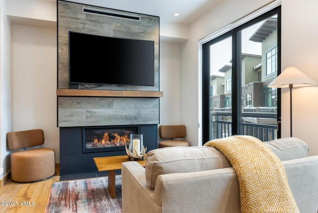 living room featuring recessed lighting, a fireplace, and wood finished floors