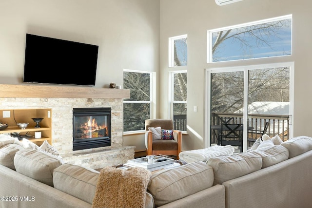 living room featuring a towering ceiling and a stone fireplace