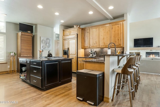 kitchen featuring decorative backsplash, a kitchen island, paneled built in fridge, and kitchen peninsula