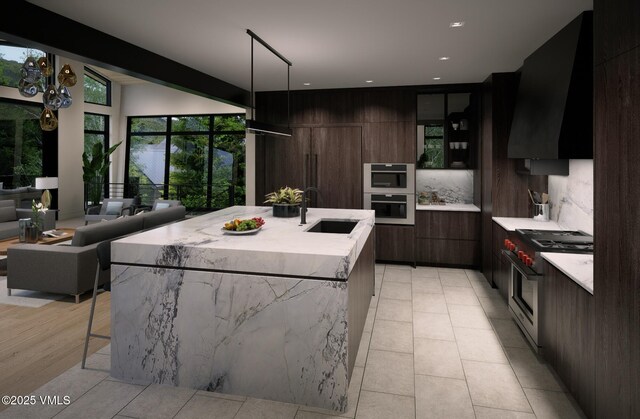 1150 Ptarmigan Rd, Vail, CO 81657 - kitchen with modern cabinets, wall chimney exhaust hood, high end range, a large island with sink, and a breakfast bar