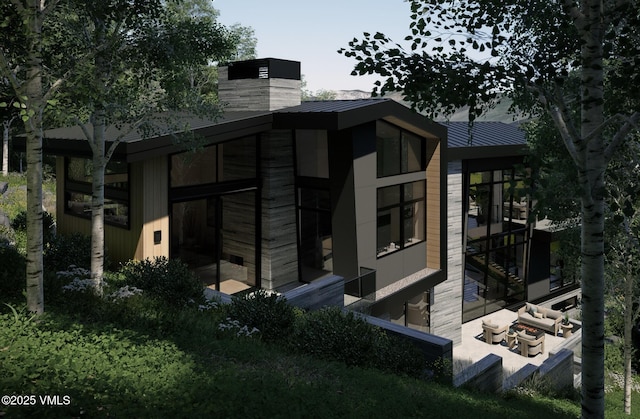 1150 Ptarmigan Rd, Vail, CO 81657 - view of side of home with a metal roof, a standing seam roof, and a chimney