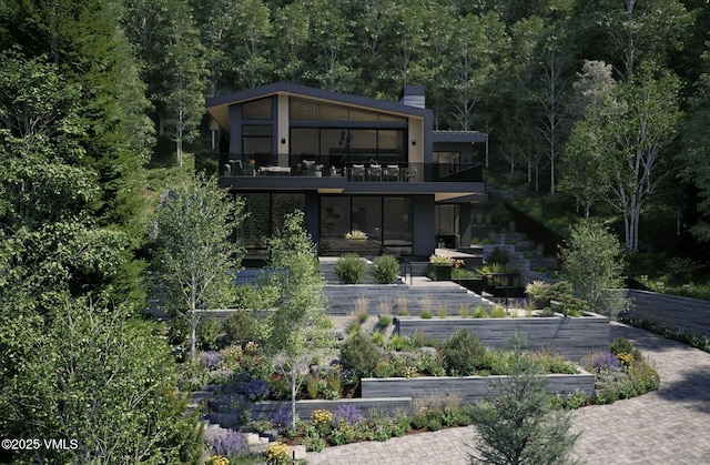 1150 Ptarmigan Rd, Vail, CO 81657 - rear view of house featuring a balcony, a chimney, and a wooded view
