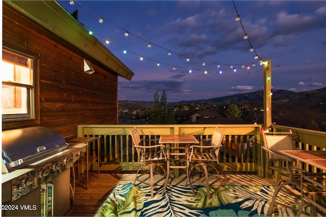 deck at dusk with area for grilling and a mountain view