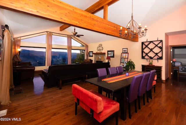 dining area featuring ceiling fan with notable chandelier, vaulted ceiling with beams, and dark wood-type flooring