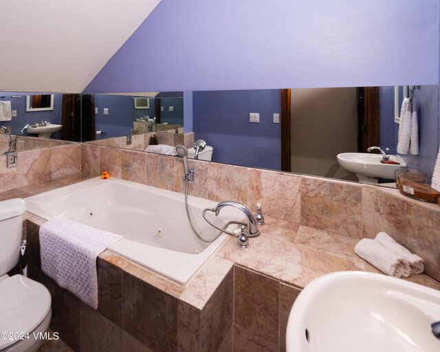 bathroom with vaulted ceiling, sink, and toilet