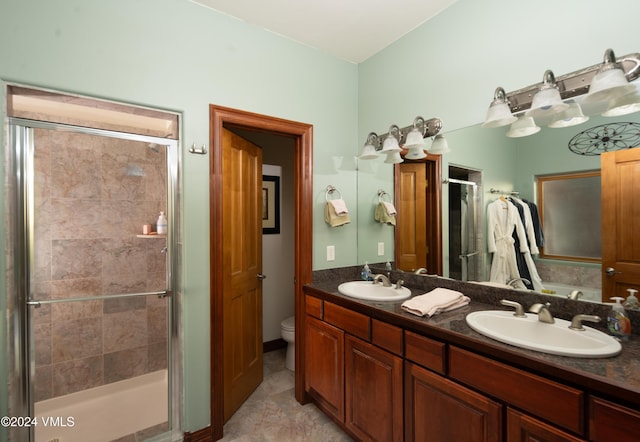 bathroom with vanity, toilet, and a shower with shower door