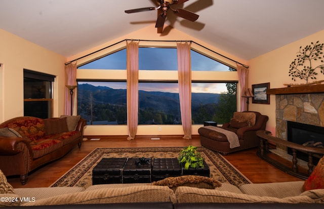 living room with a mountain view, vaulted ceiling, a fireplace, and wood-type flooring