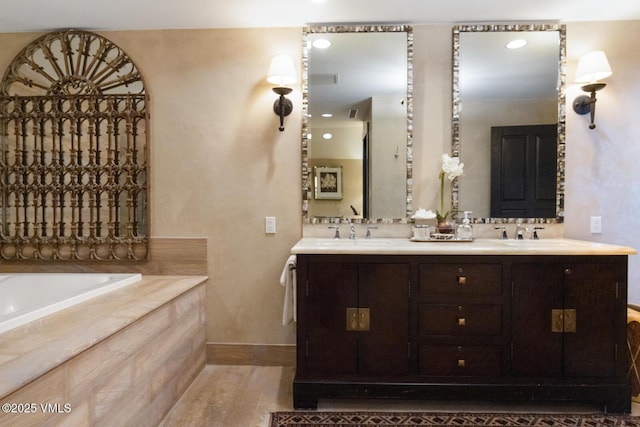 bathroom featuring double vanity, a garden tub, baseboards, and a sink