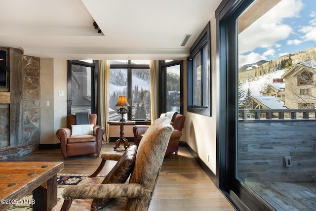 sunroom / solarium with visible vents, a mountain view, and a fireplace